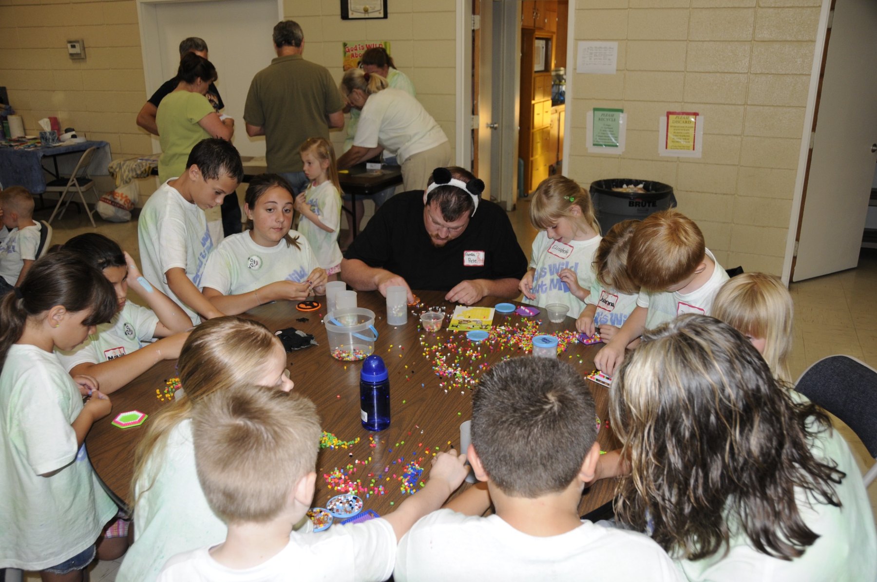 Children and adults working together on a Vacation Bible School craft activity