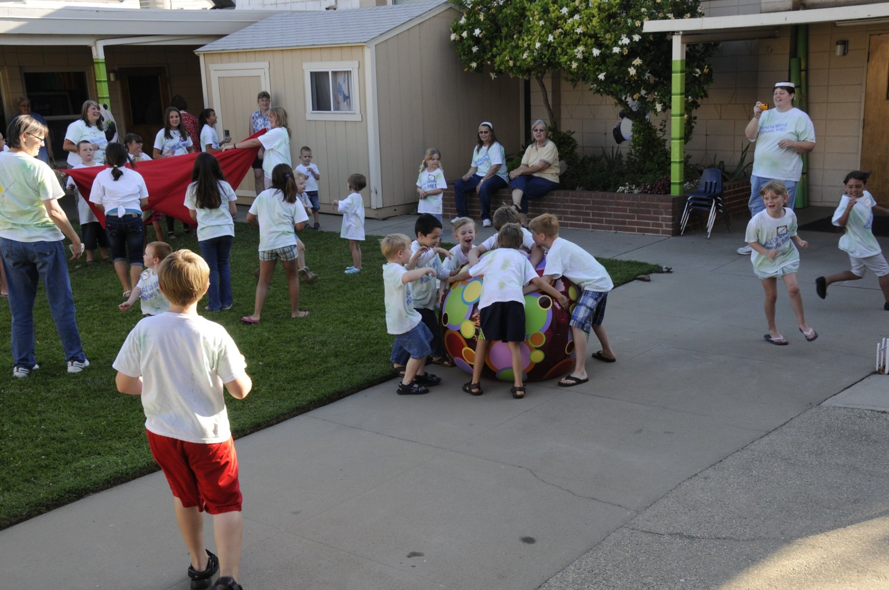 Children and volunteers taking part in an outdoor Vacation Bible School activity