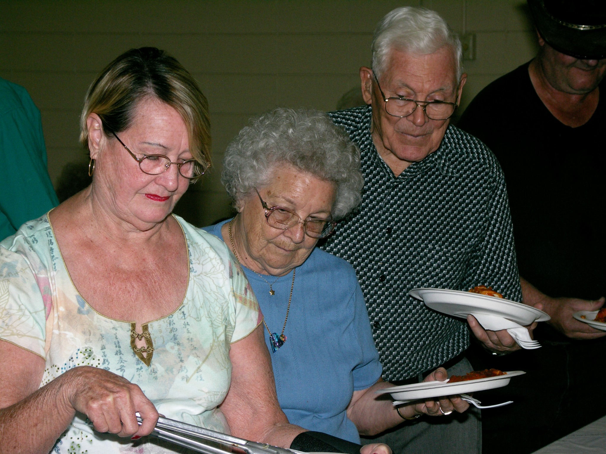 People serving themselves from the buffet line at a church community dinner.