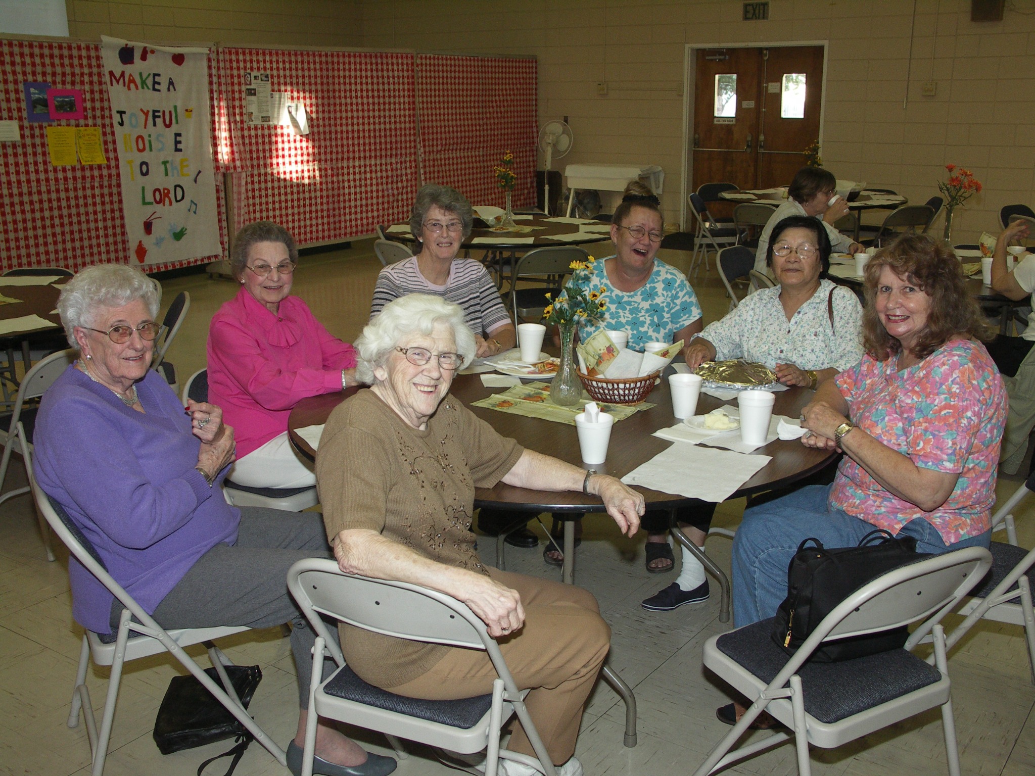 A group of women seated around a table during a church community dinner.