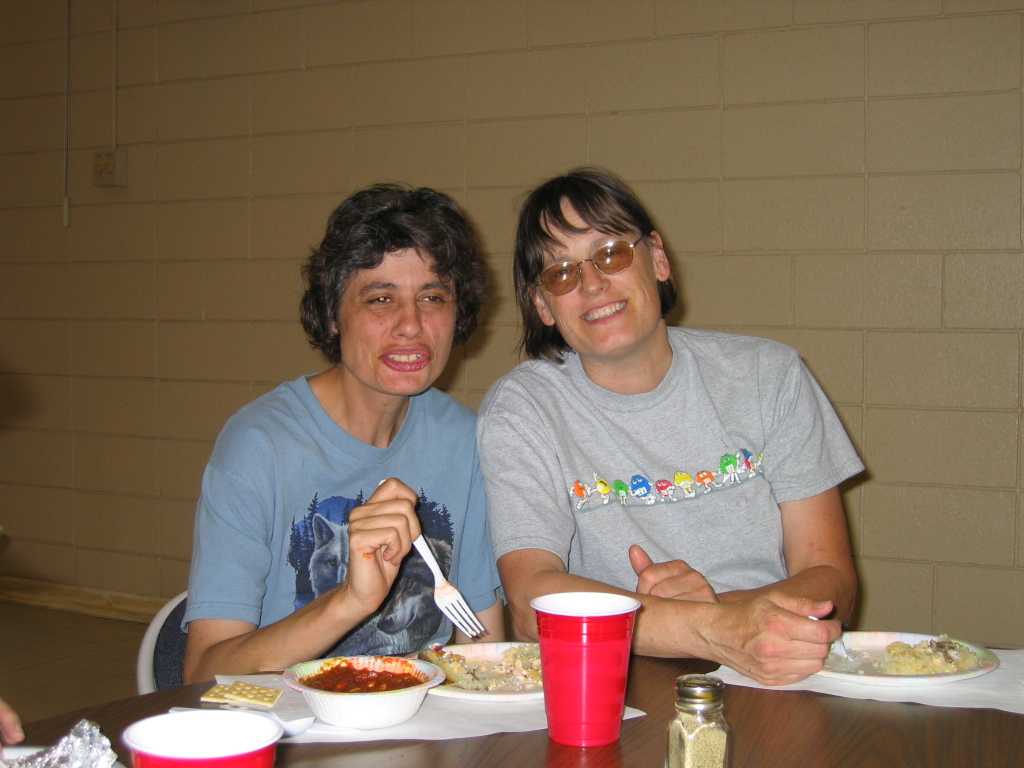 Two women enjoying a meal at a church community dinner.