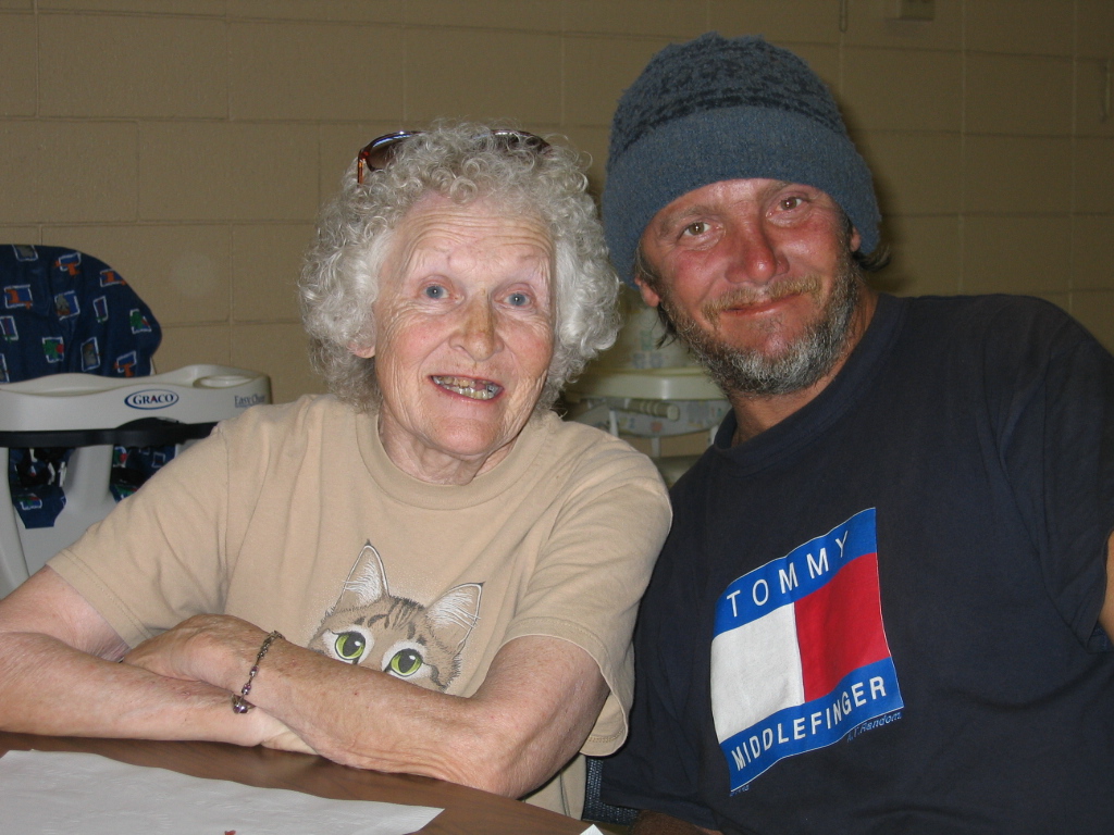 An older woman and man seated together at a church community dinner.