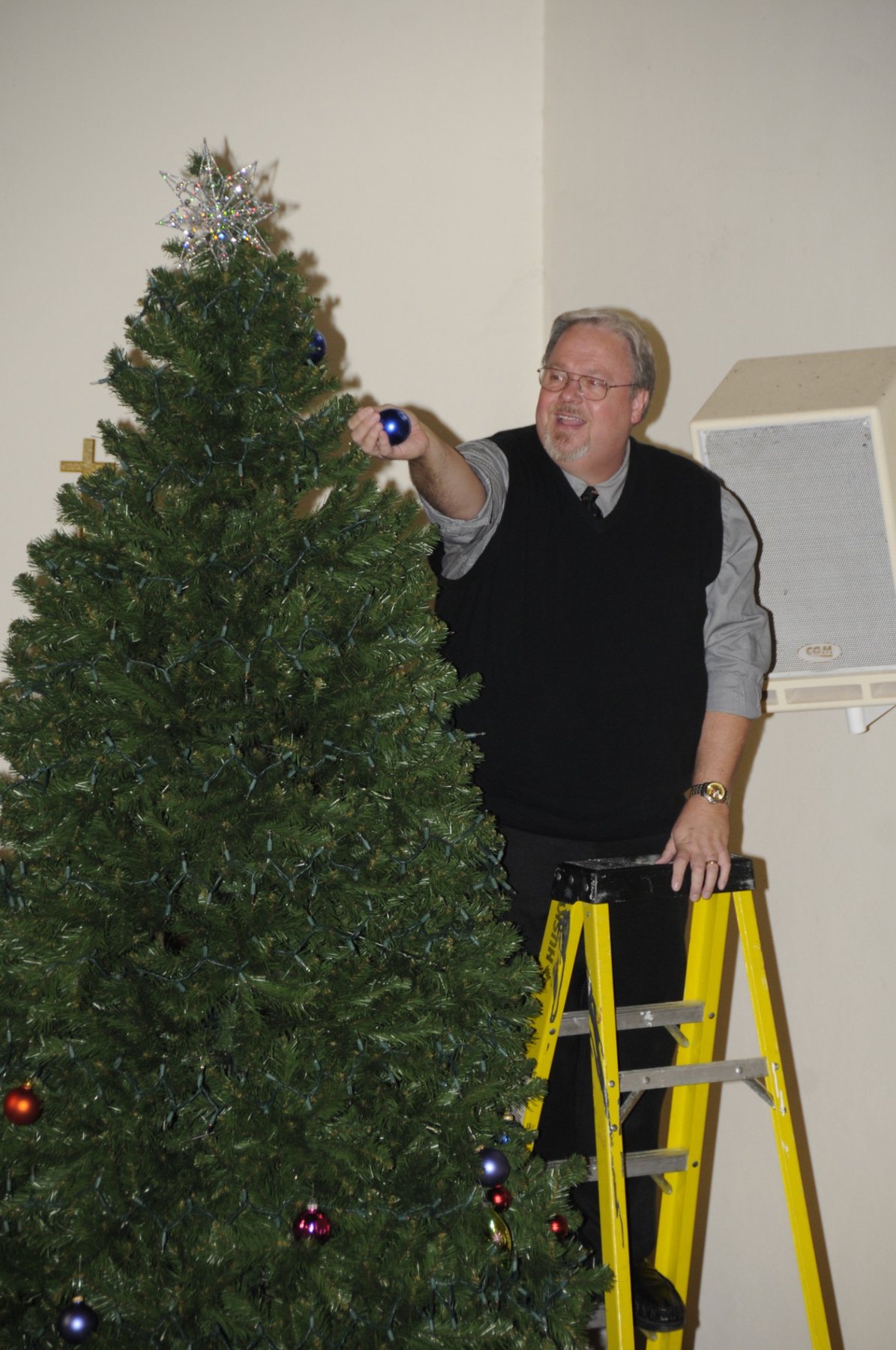 Decorating the sanctuary Christmas tree.