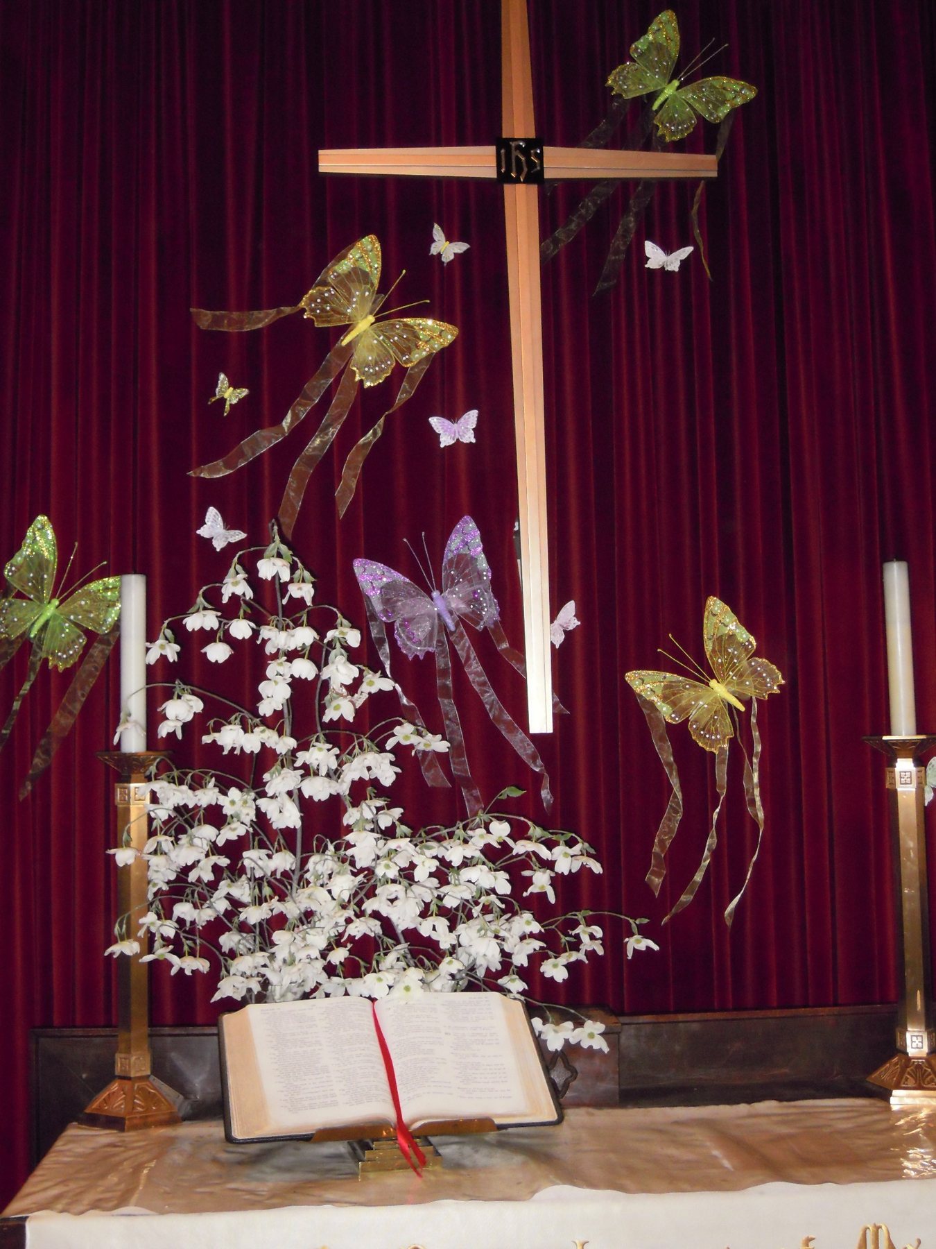 An Easter altar arrangement with butterflies and blossoms.