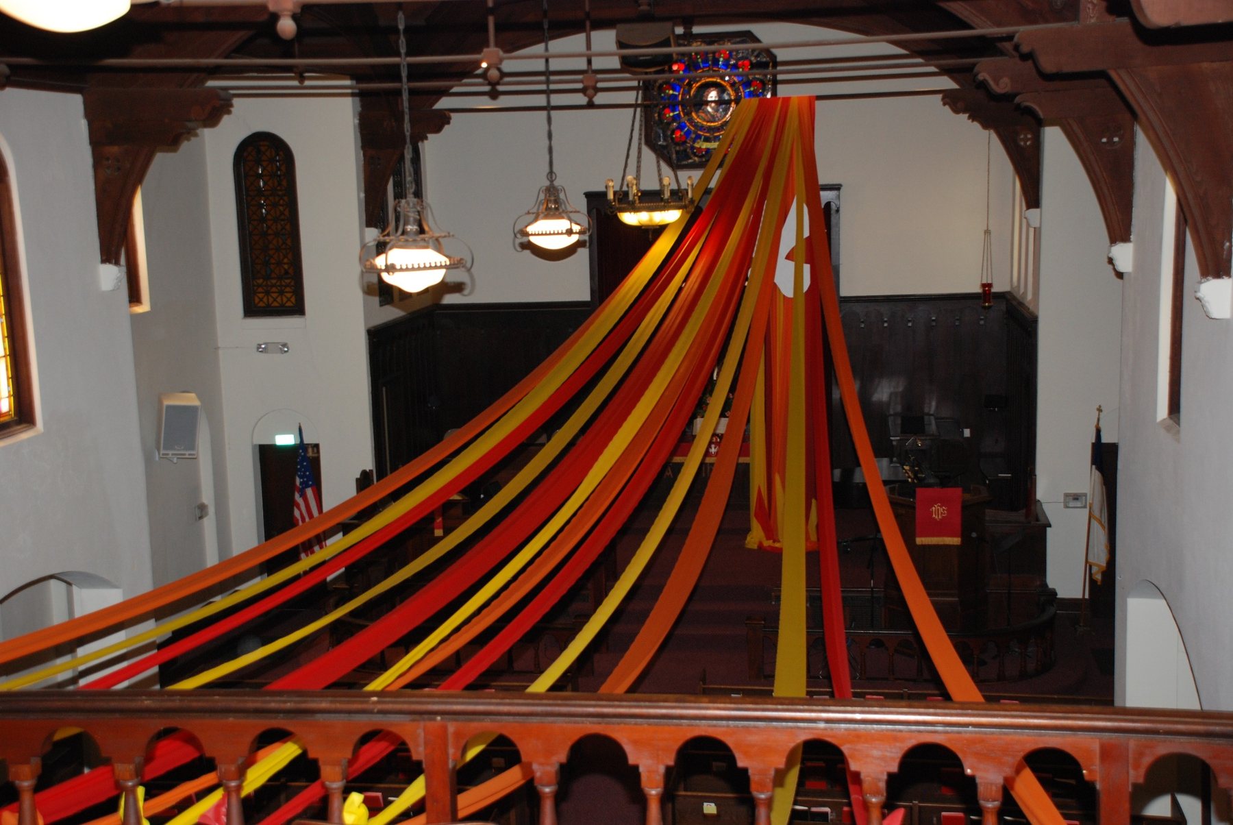Pentecost ribbons sweep from the balcony toward the chancel.