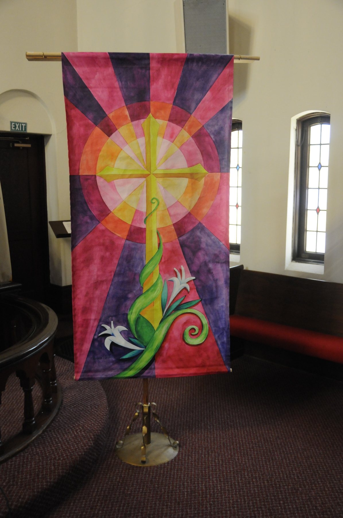A colorful cross banner displayed in the sanctuary.